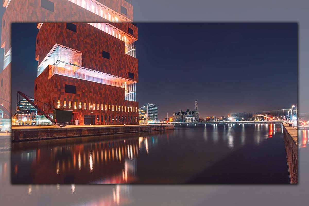 Nachtelijk panorama van het prachtige MAS museum met weerspiegeling in het Bonapartedok, Antwerpen