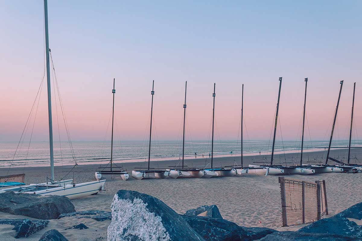 Rij zeilboten op het strand van Oostende bij zonsondergang