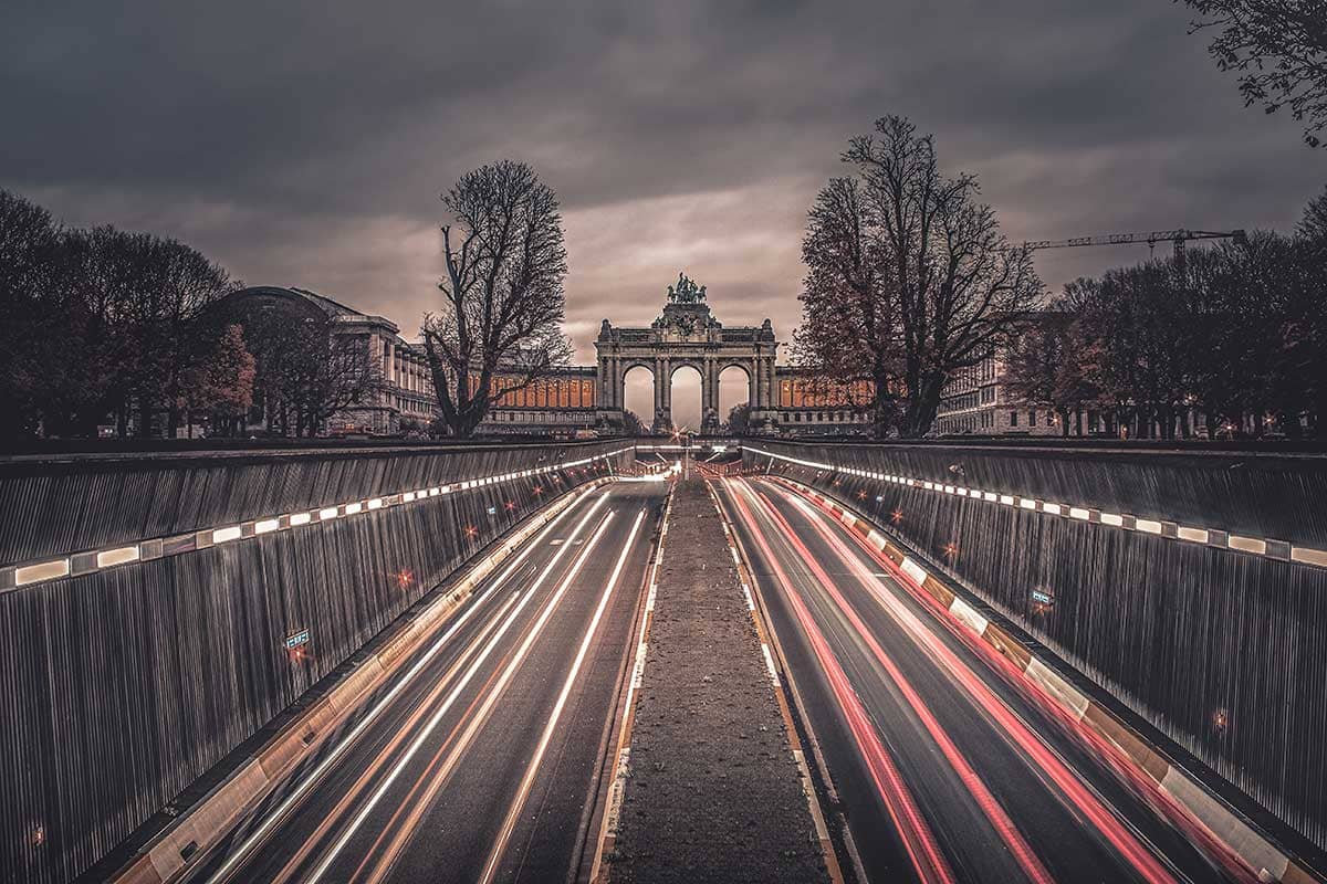 Light trails van het verkeer in Brussel met uitzicht op de triomfbogen van de Cinquantenaire