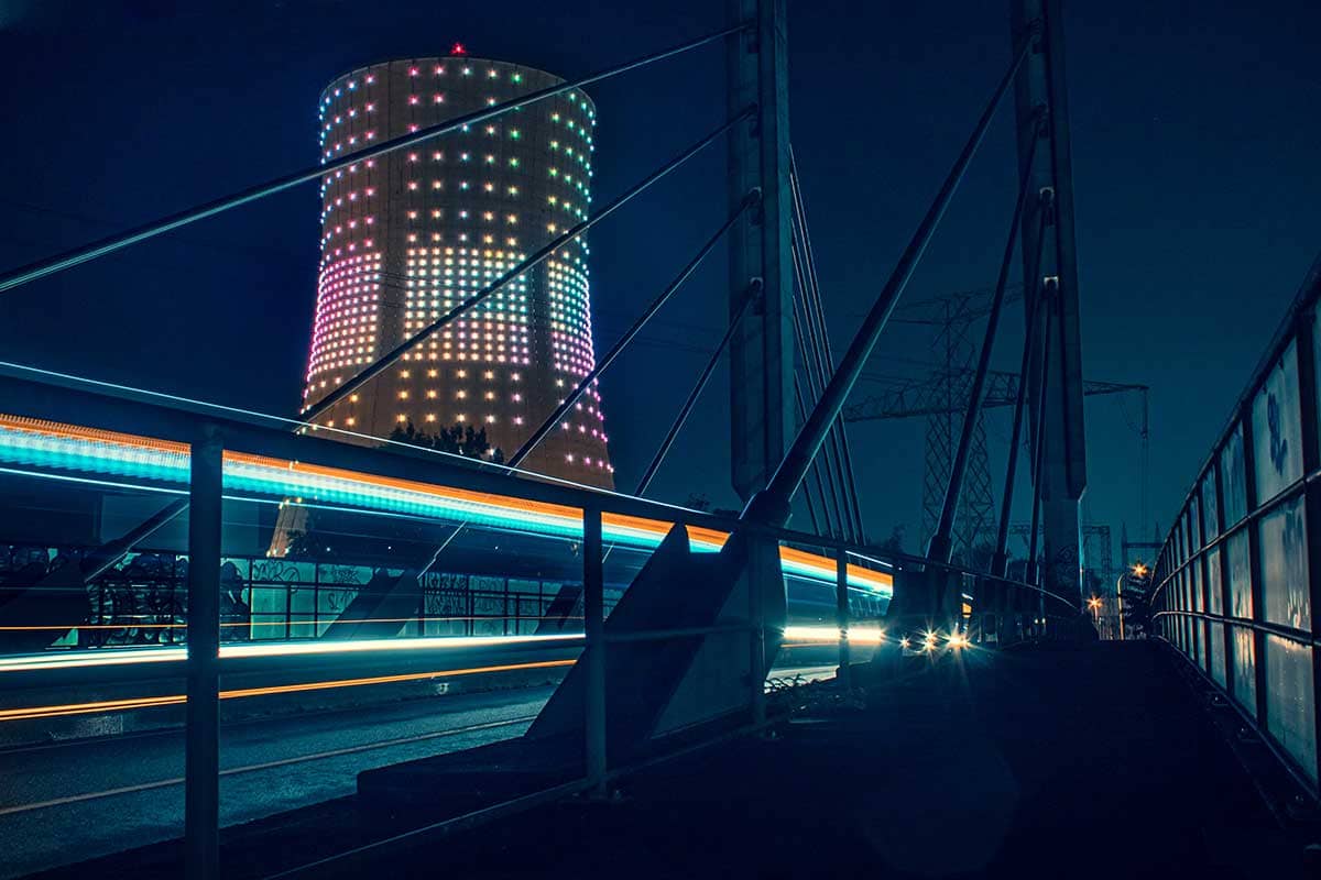 Long Exposure van voorbij rijdende bus met verlichte koeltoren